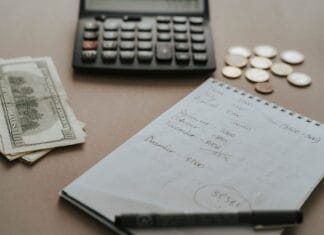 Rok do ślubu: szczegółowy plan oszczędzania, rezerwacji i płatności, który pomoże rozłożyć wydatki i uniknąć finansowego chaosu Biurko z kalkulatorem, gotówką i notatkami do planowania budżetu ślubu
