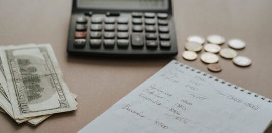 Biurko z kalkulatorem, gotówką i notatkami do planowania budżetu ślubu